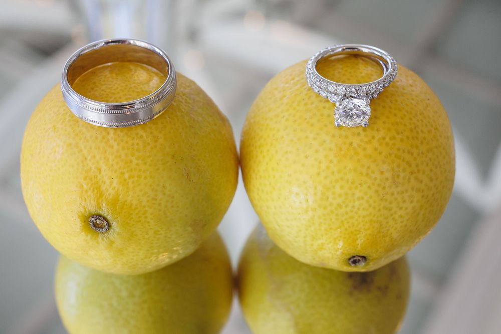 Wedding rings creatively displayed on fresh yellow citrus fruits.
