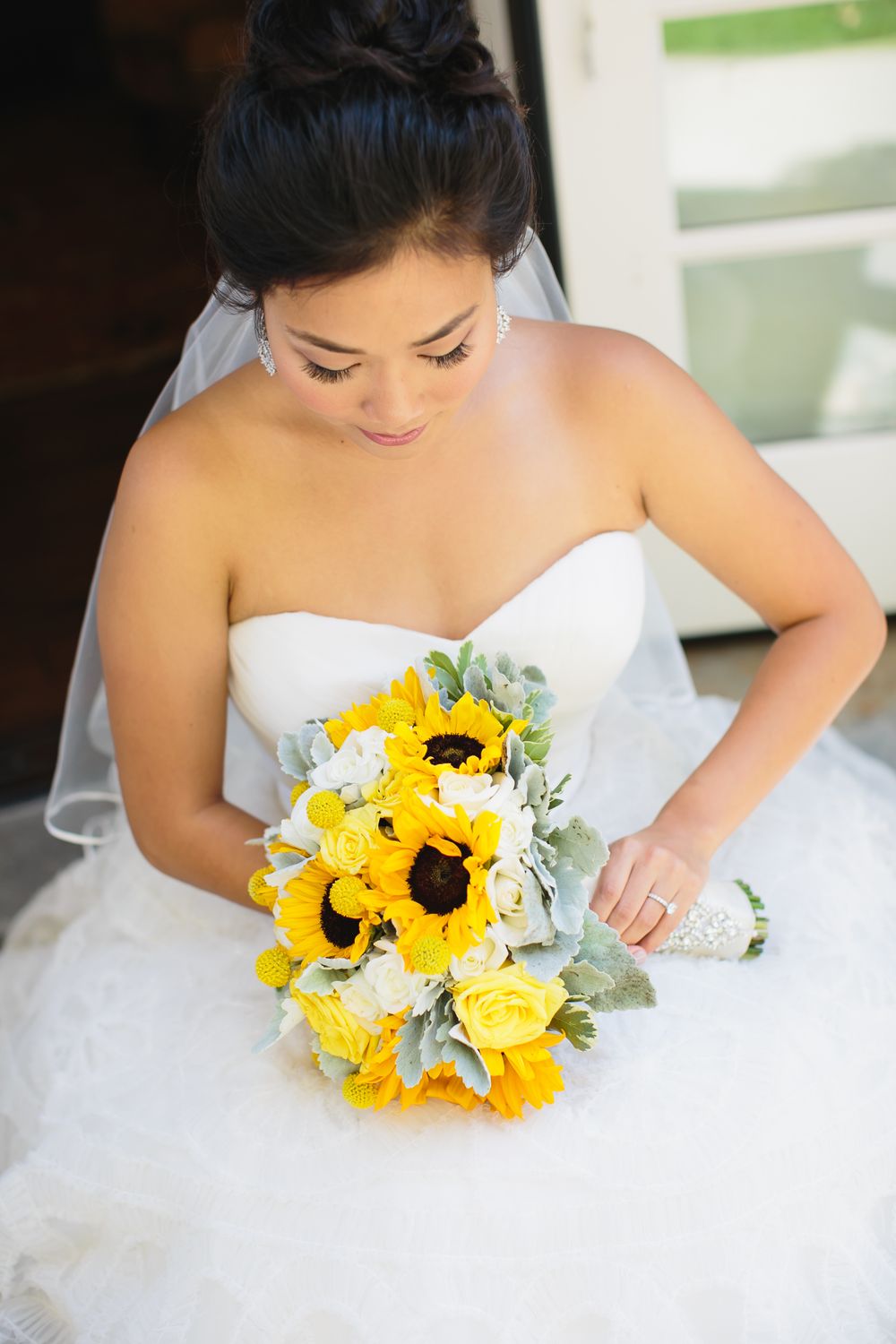 Bright yellow sunflower wedding bouquet with white bridal dress.