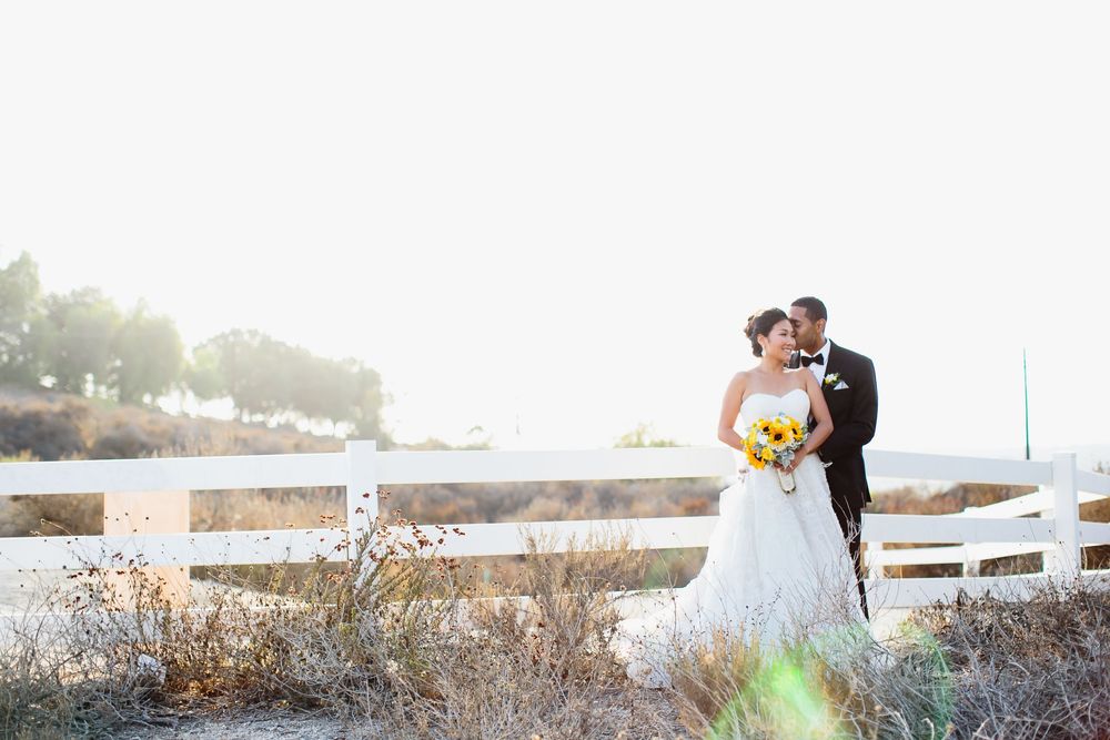 Scenic waterfront wedding portraits at sunset with soft natural lighting.