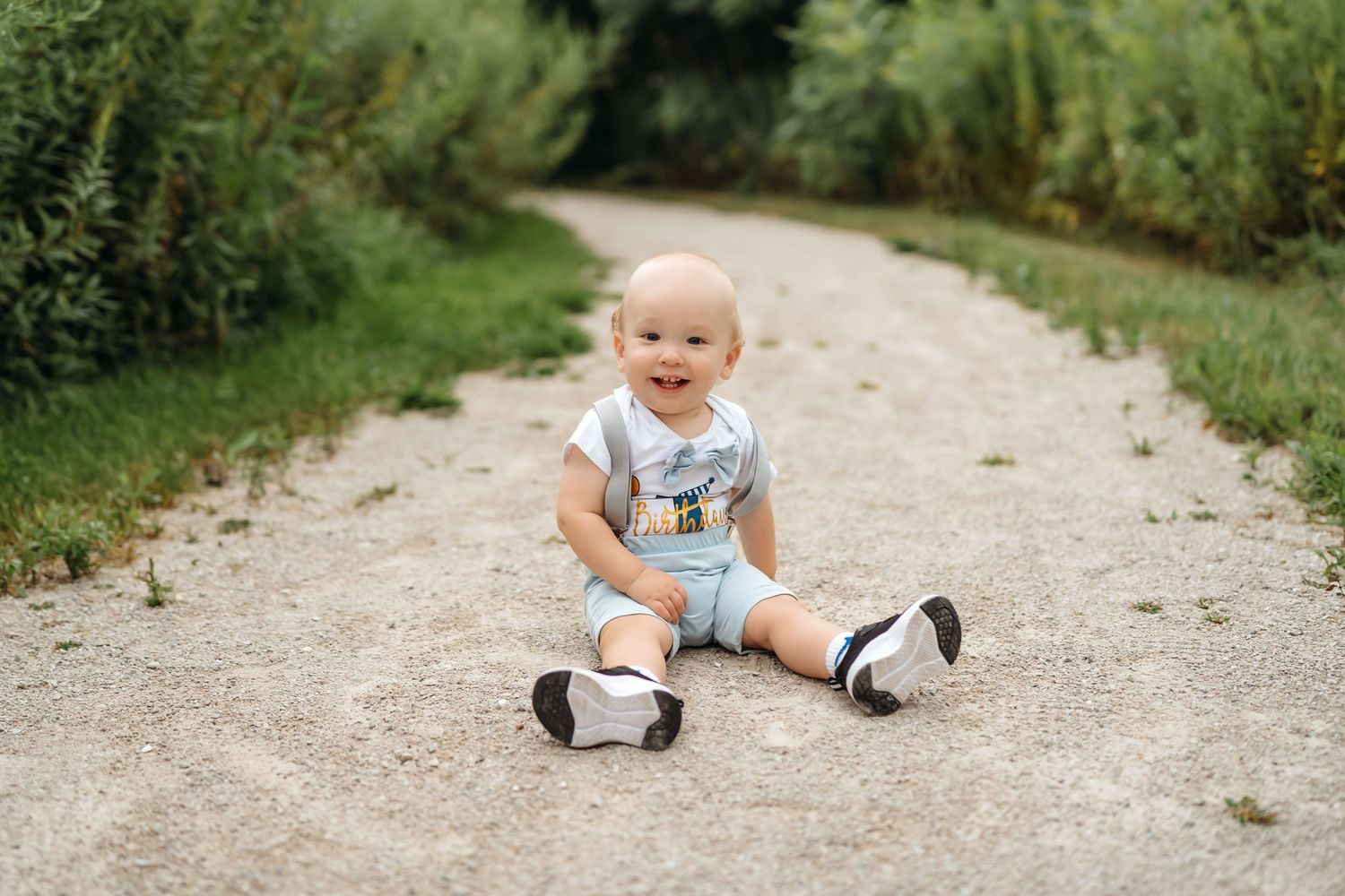 Series of candid photos showing a child sitting and playing on a gravel path in a natural outdoor setting.