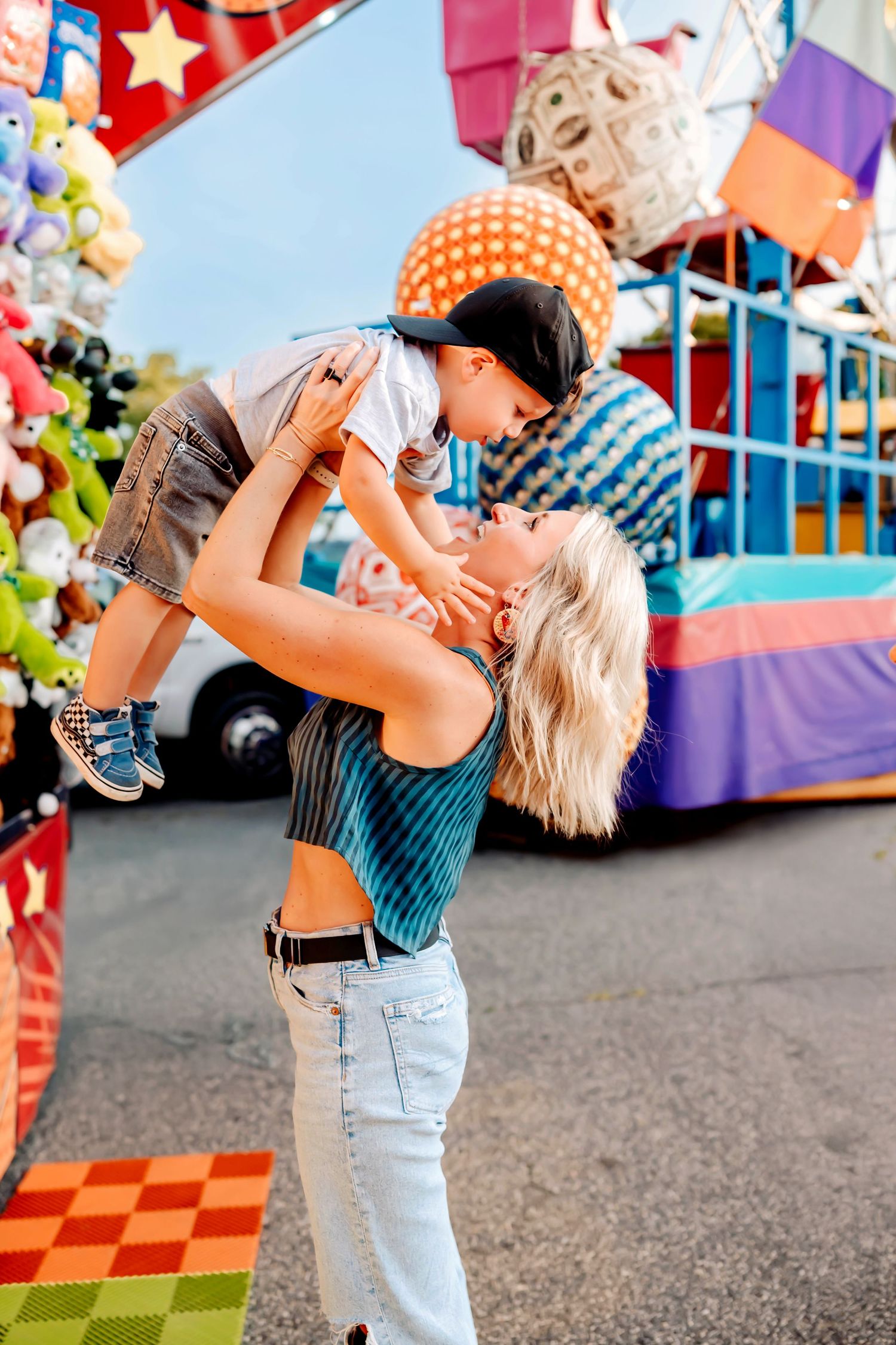 Joyful moment at a carnival with colorful rides and decorations in the background.