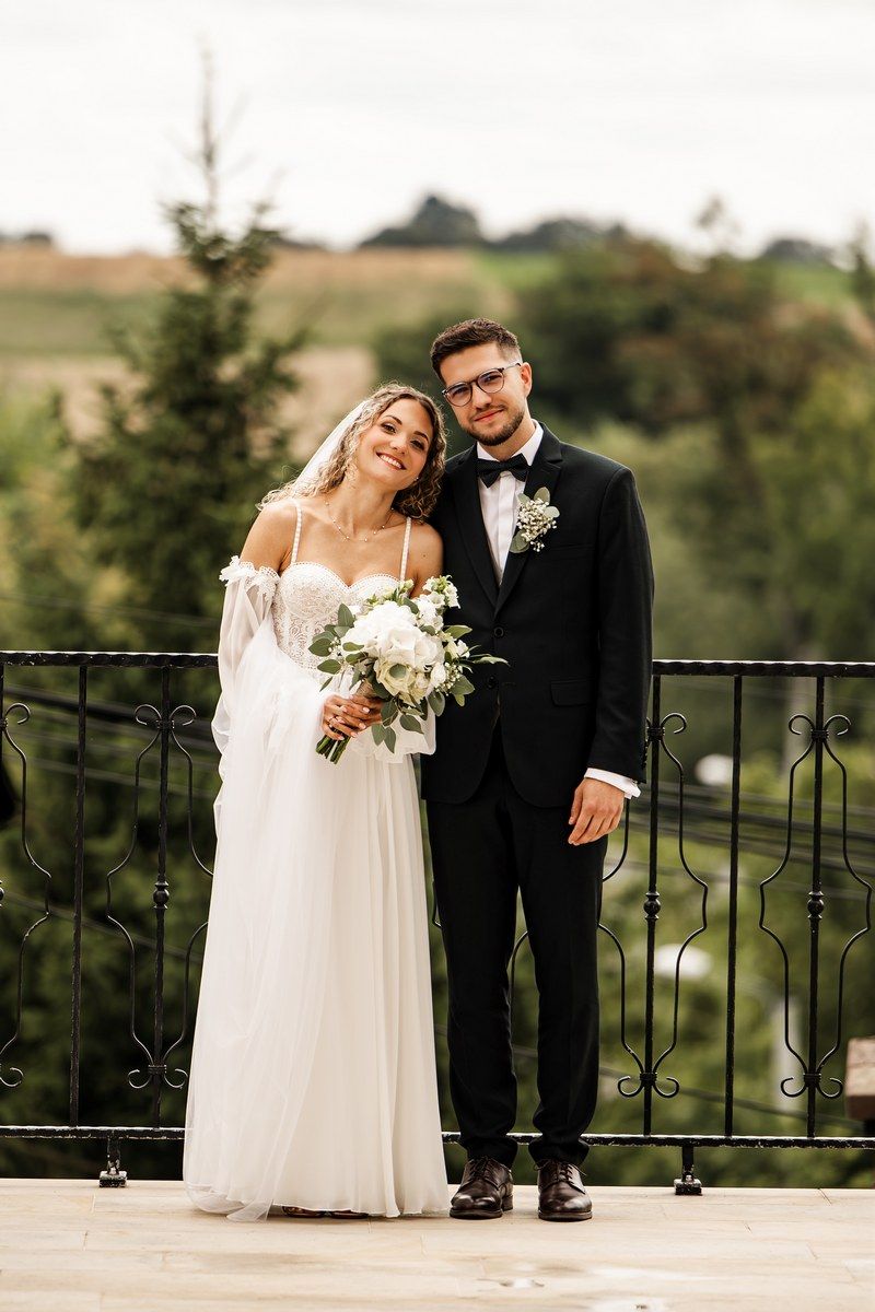Wspólne zdjęcie pary młodej przed wejściem do kościoła
