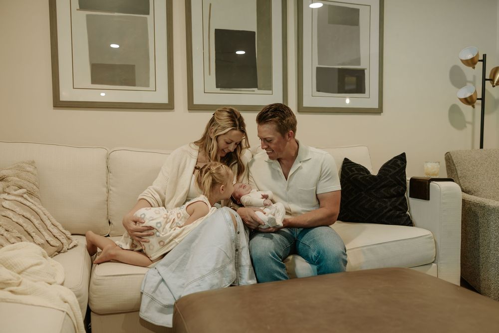 Family relaxing on cozy white couch while spending intimate moments together at home.