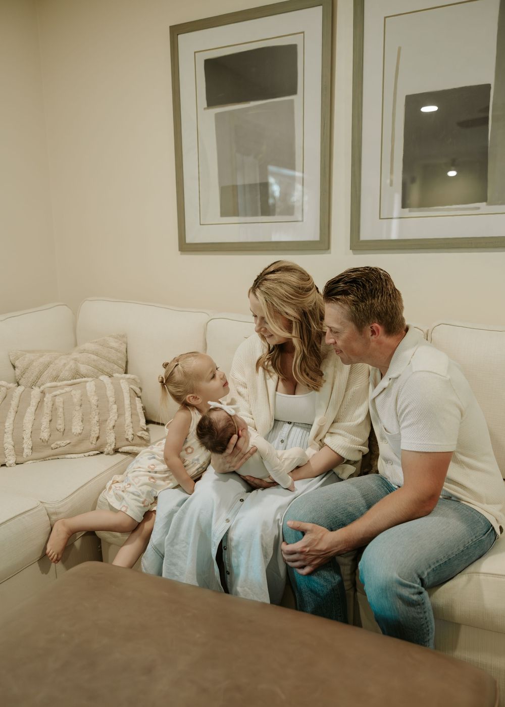 Parents sit together on a couch in a tender family moment captured in a series of connected photos.