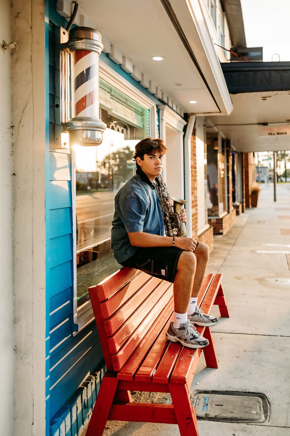 A series of side-by-side images showing a person sitting on a red bench under a covered outdoor walkway.