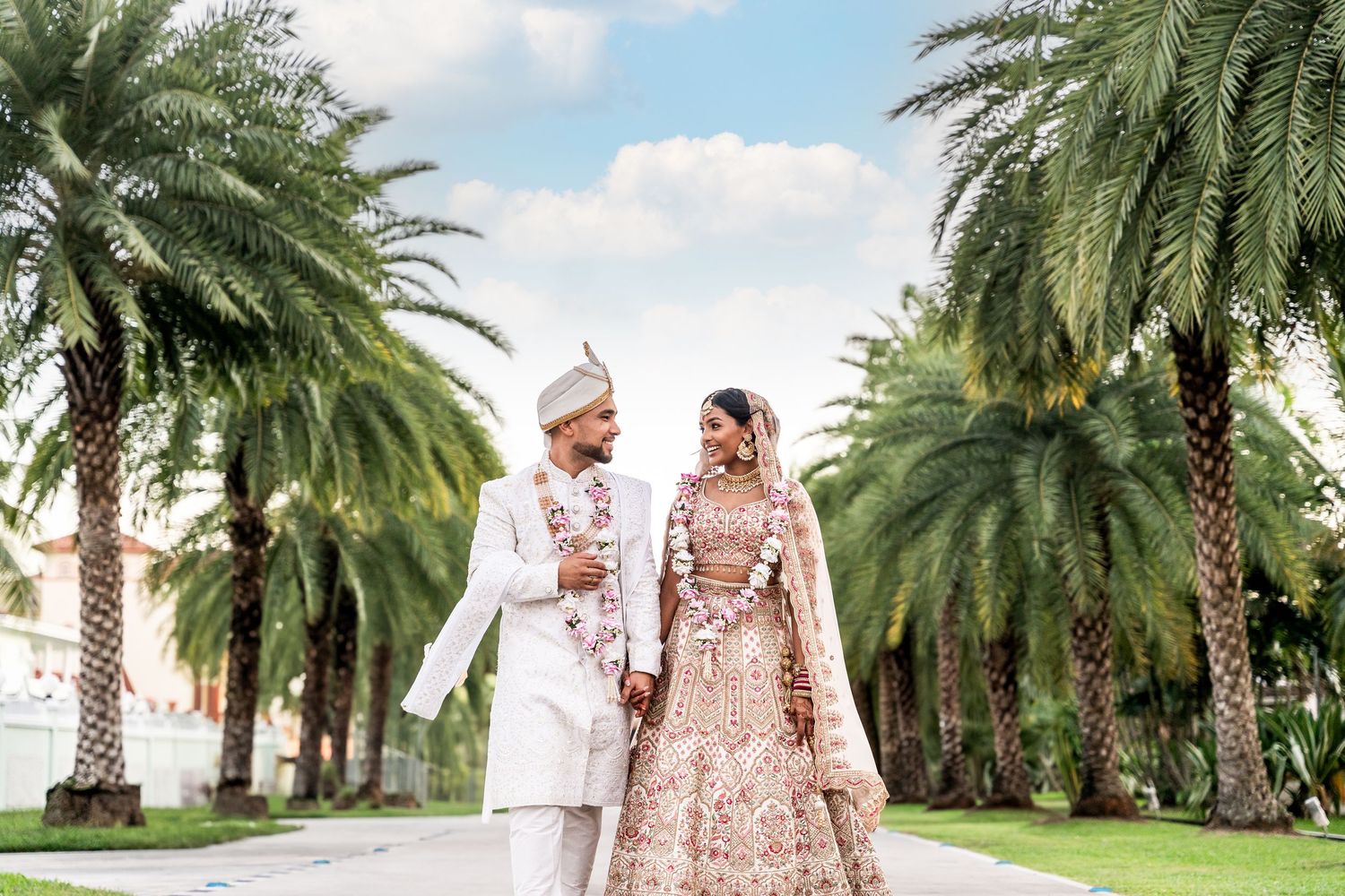 Palm tree lined pathway creates an elegant tropical backdrop for special occasions.