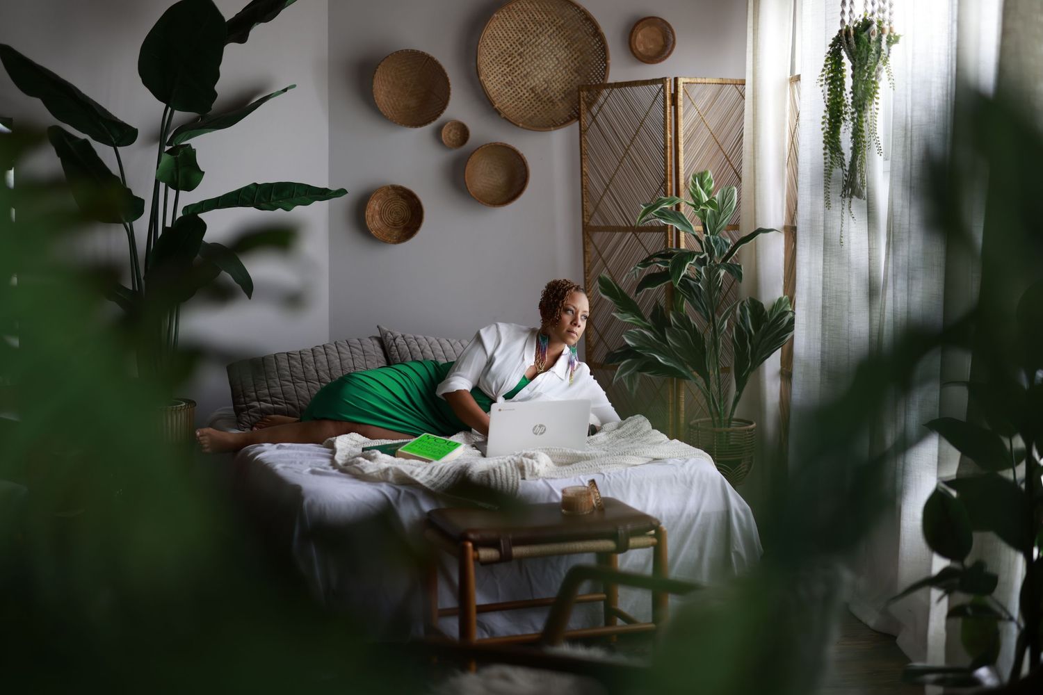 Indoor photoshoot setup with decorative woven baskets and tropical plants creating a cozy bohemian atmosphere.