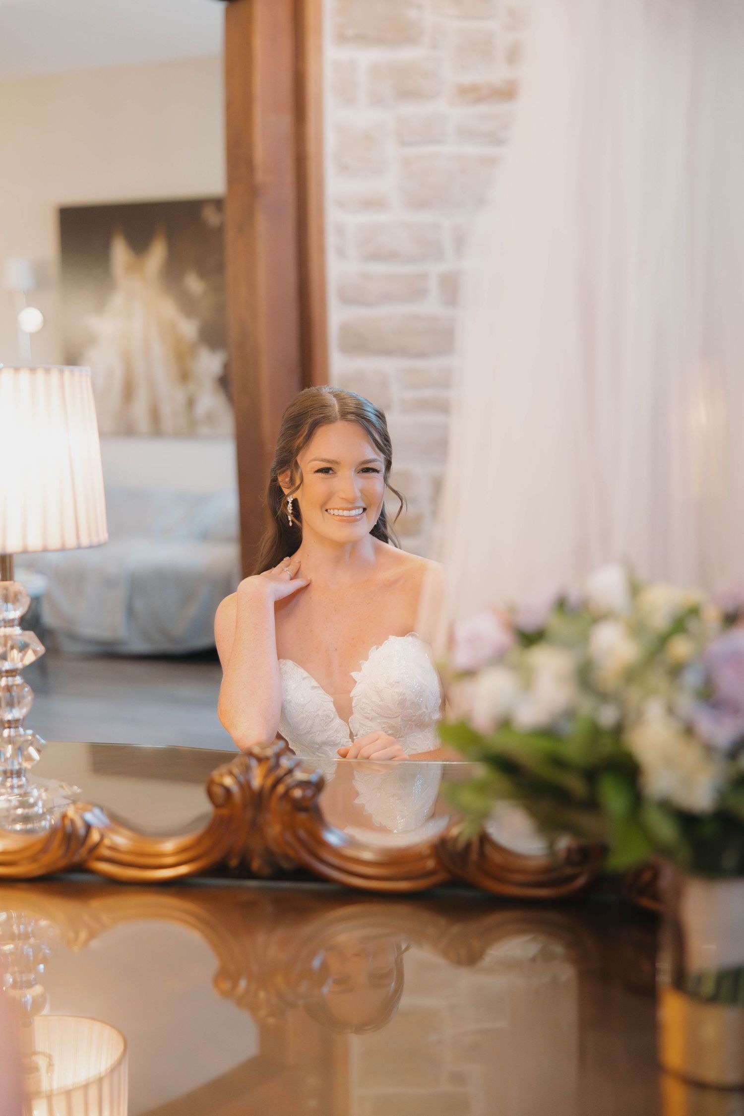 Elegant wedding venue setup with brick walls, warm lighting and floral arrangements on display.