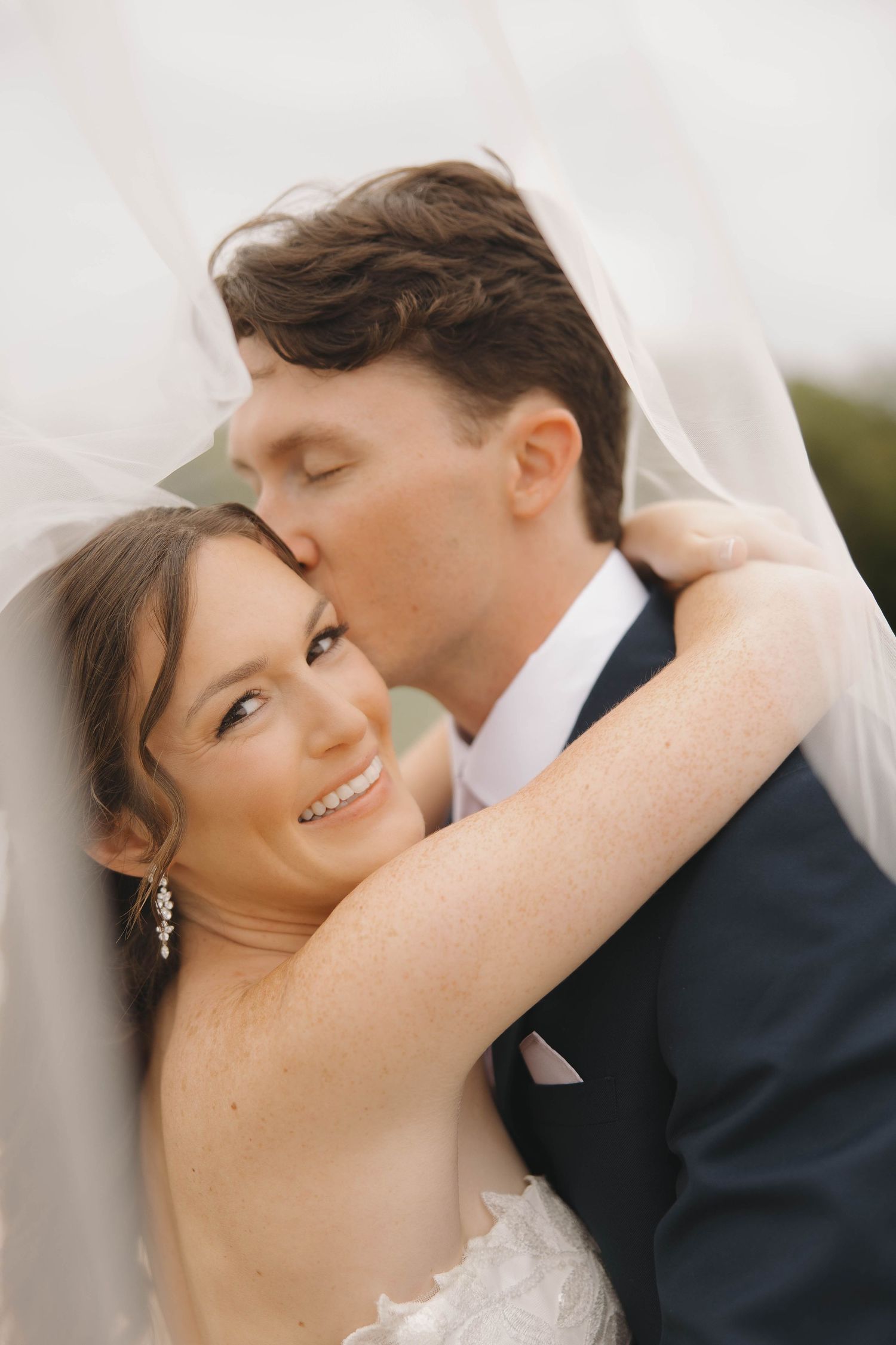 Close-up wedding photography sequence showing tender moments between bride and groom under a veil.