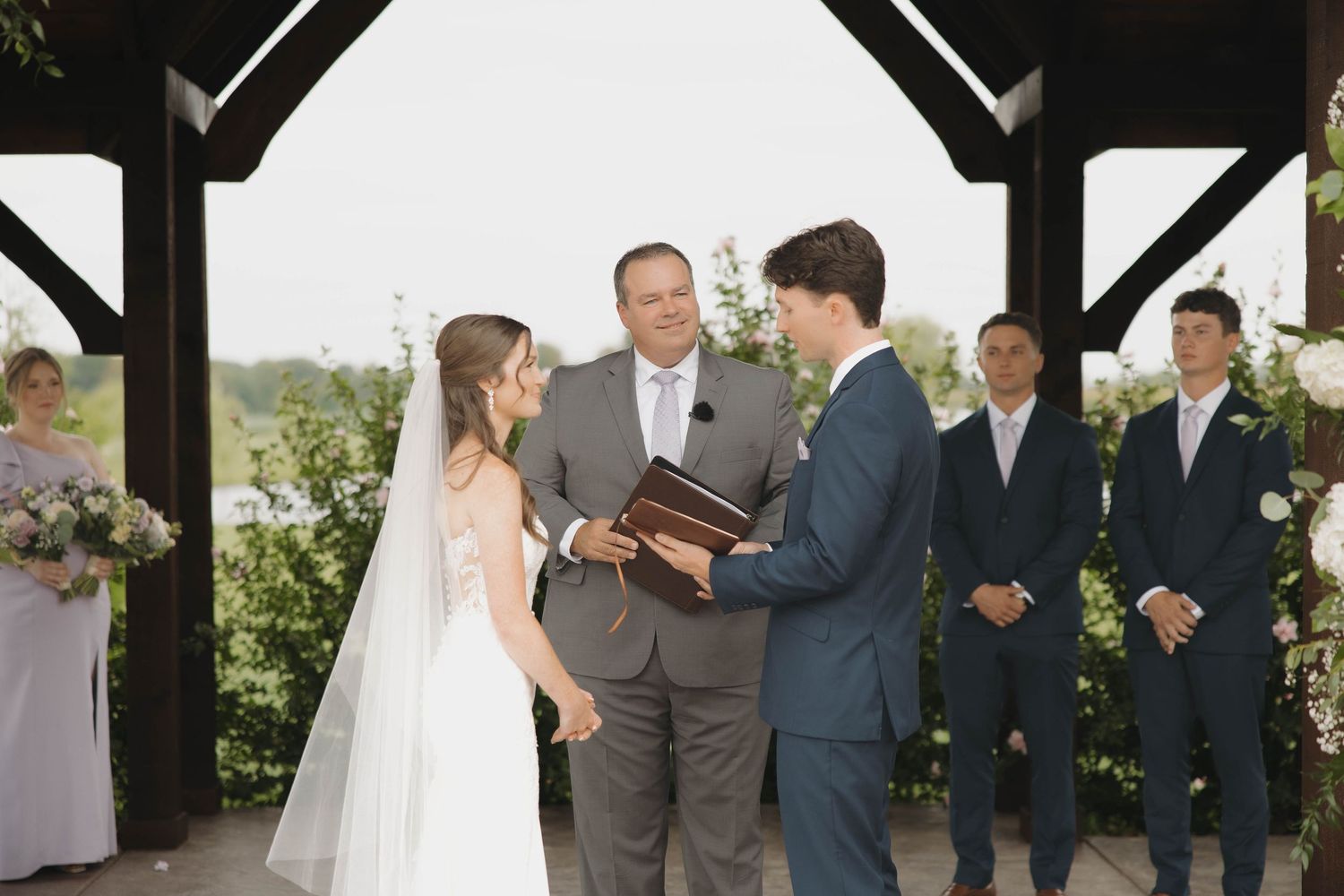 Wedding ceremony sequence shows couple exchanging vows under a rustic wooden pavilion.