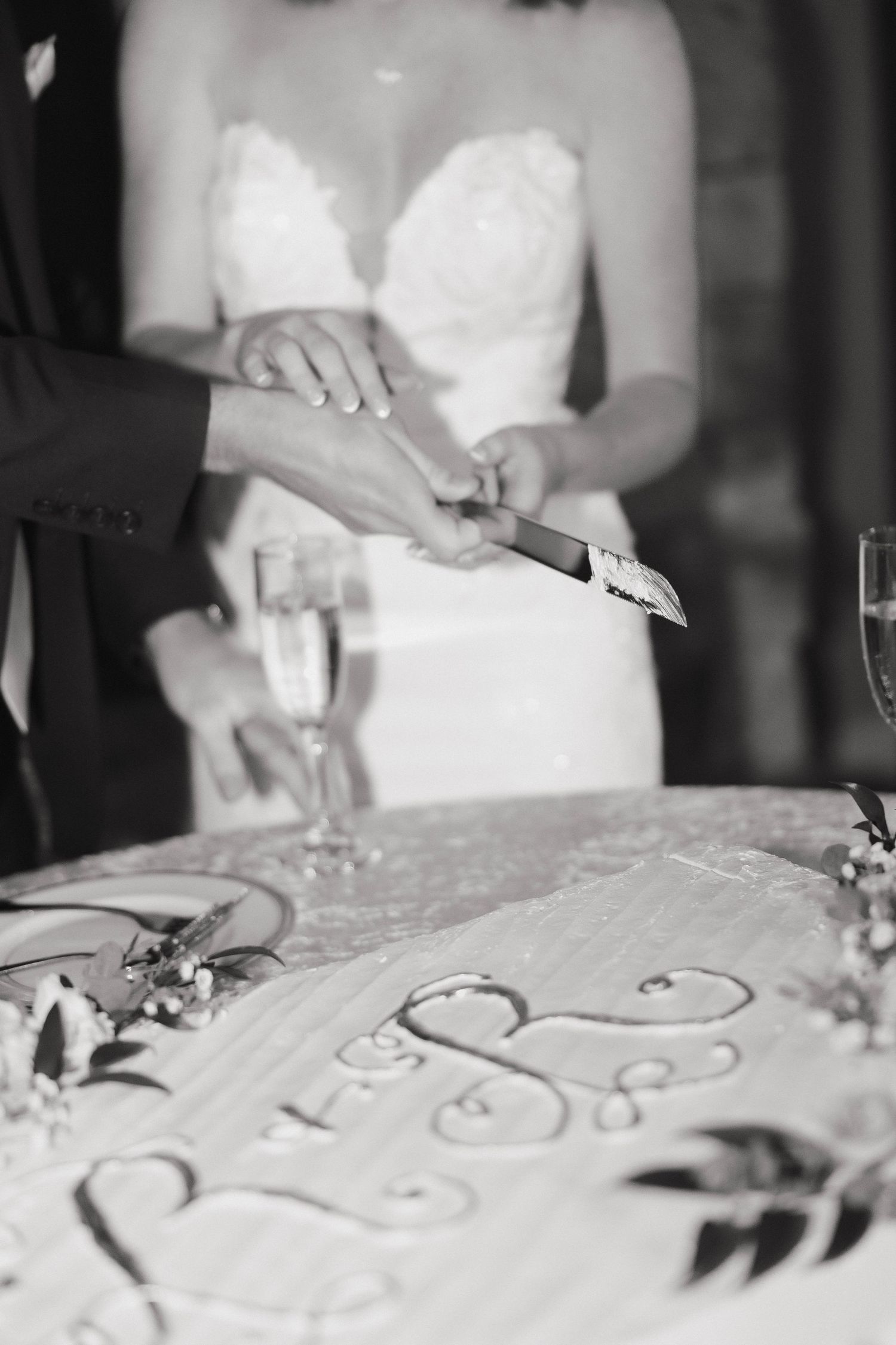 A series of monochromatic images showing hands writing calligraphy on white fabric or paper in a decorative pattern.