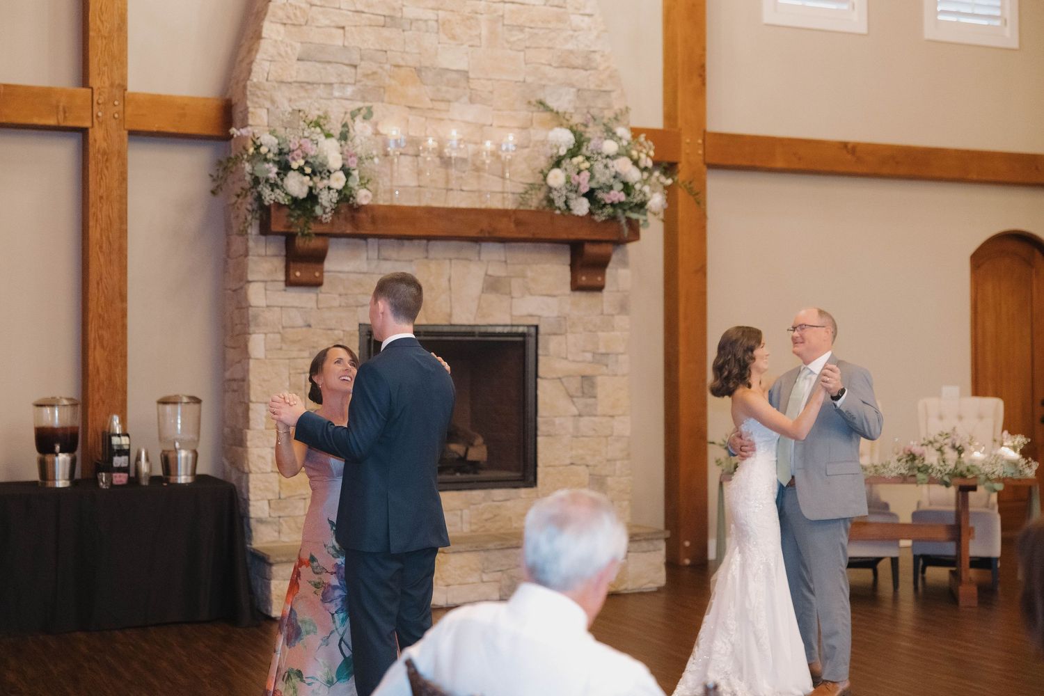 Wedding reception celebration inside a rustic venue with wooden beams and stone walls.