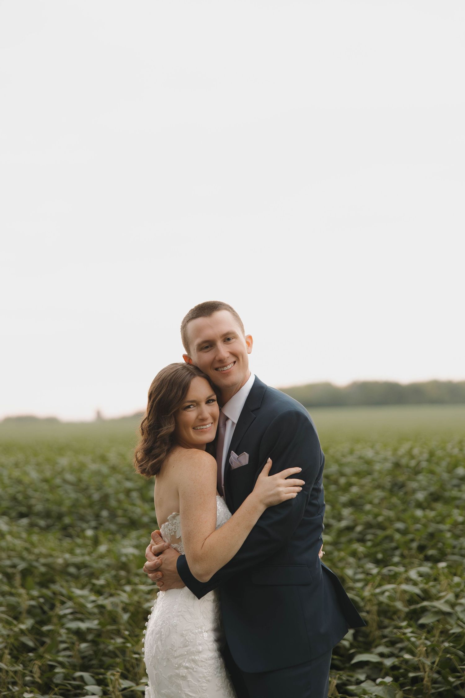 A couple shares intimate moments against a green soybean field backdrop.