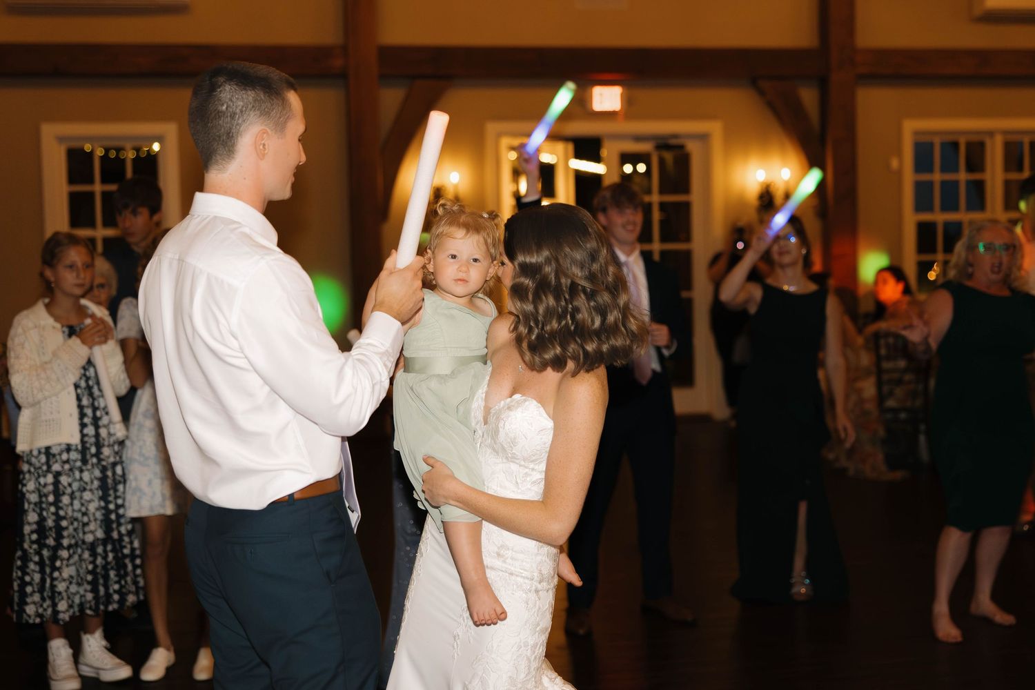 Dimly lit wedding reception with dancing and celebration in an elegant ballroom setting.