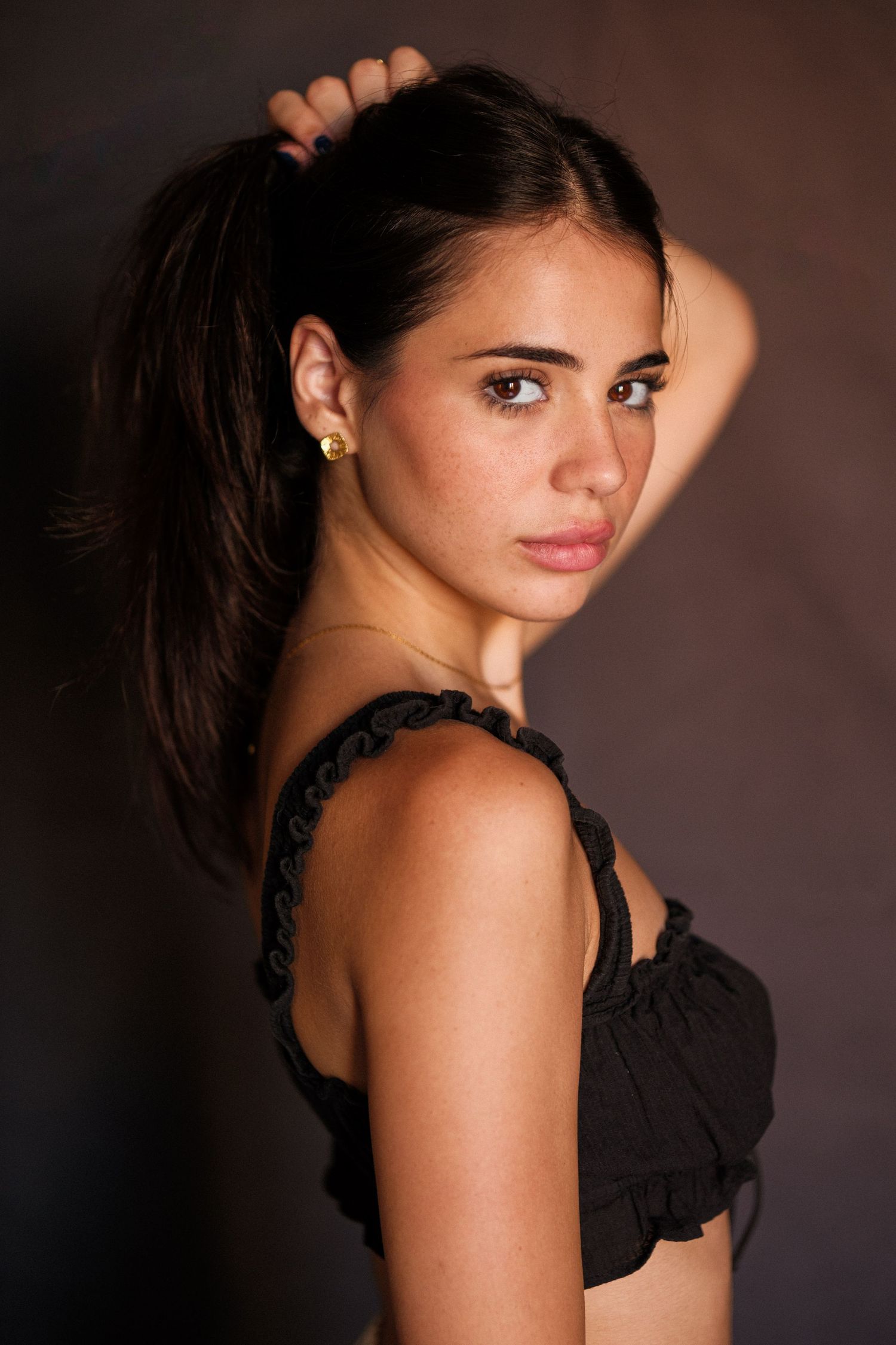 Artistic boudoir portraits with person wearing black lace against dark backdrop.