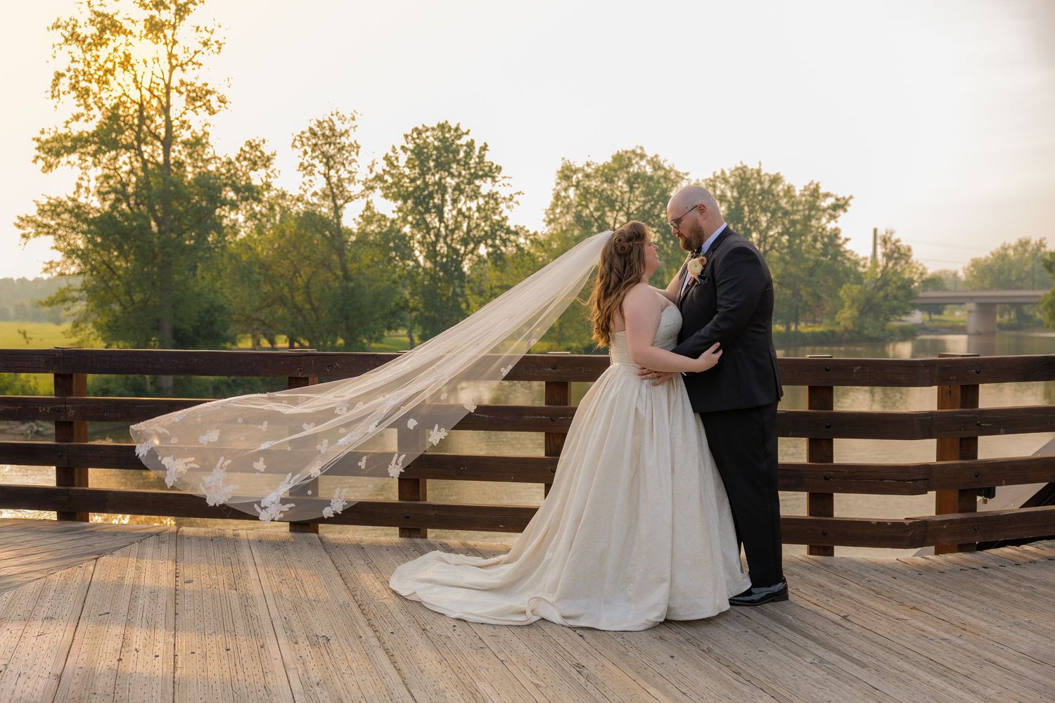 Bride and groom on bridge with veil sweeping in the air at midtown michigan