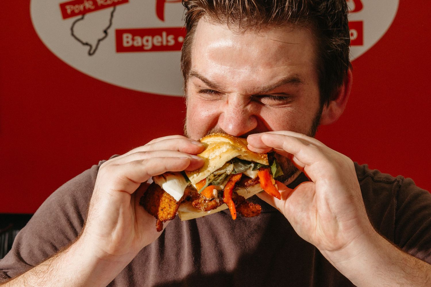 Close-up shots of someone eating a large sandwich against a red background.