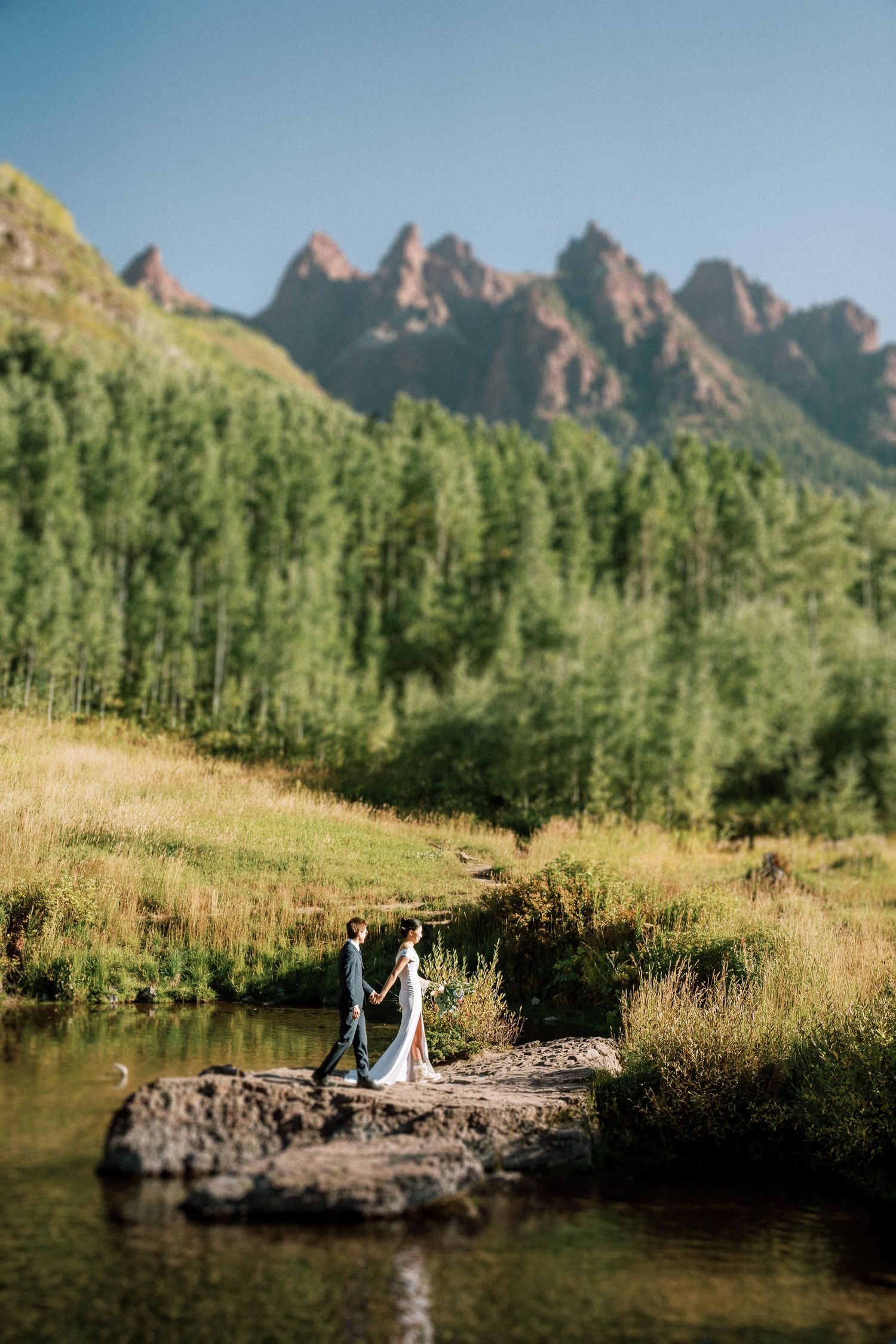 A couple walking on a rock at Maroon Bells. Aspen elopement photographer. Adventure elopement Aspen.