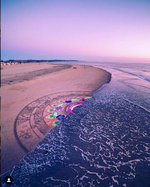 Aerial view of beach shoreline at sunset with scattered umbrellas and intricate wave patterns in purple light.