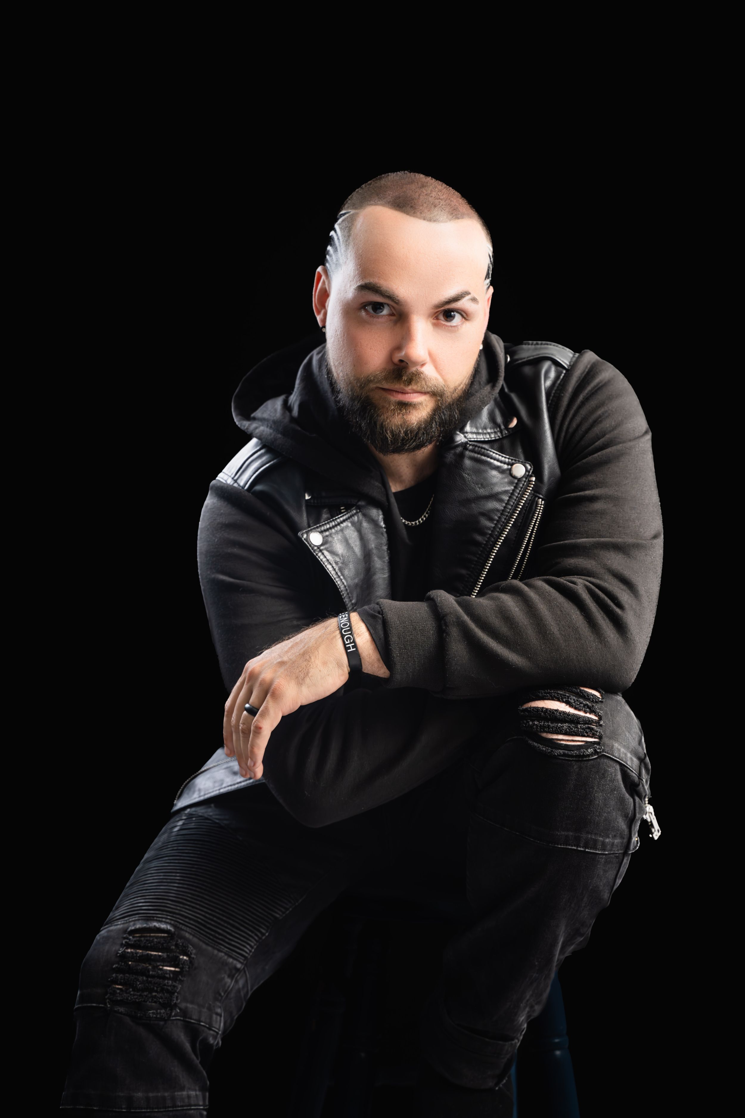 Dramatic black and white portrait series showing someone in dark clothing against a black background in moody poses.