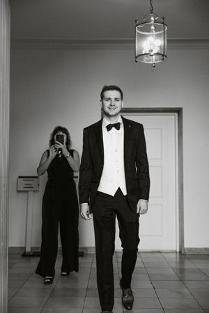 Black and white series of groomsmen walking confidently down a hallway.