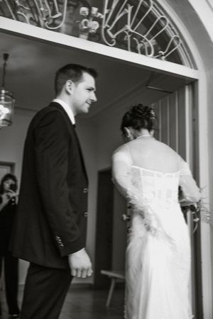 Series of candid black and white moments between newlyweds in an arched hallway.