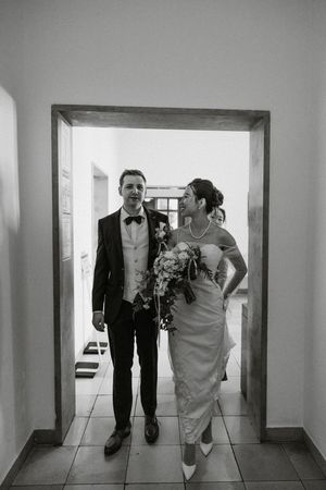 Black and white sequence of wedding party walking through building hallways.