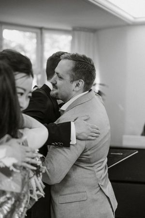 Emotional embrace shared between wedding party members during celebration.