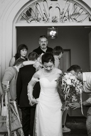 Black and white wedding celebration photos under ornate archways with guests enjoying festivities.