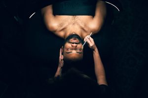 Close-up upside-down view of esthetician performing facial treatment on client.