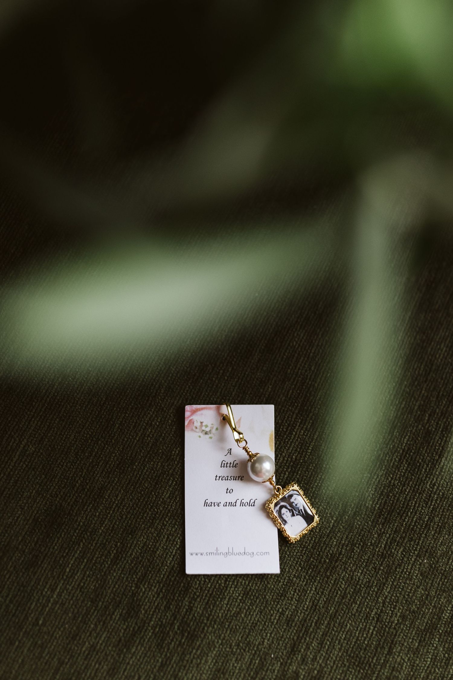 Delicate gold jewelry piece displayed on dark textured background.
