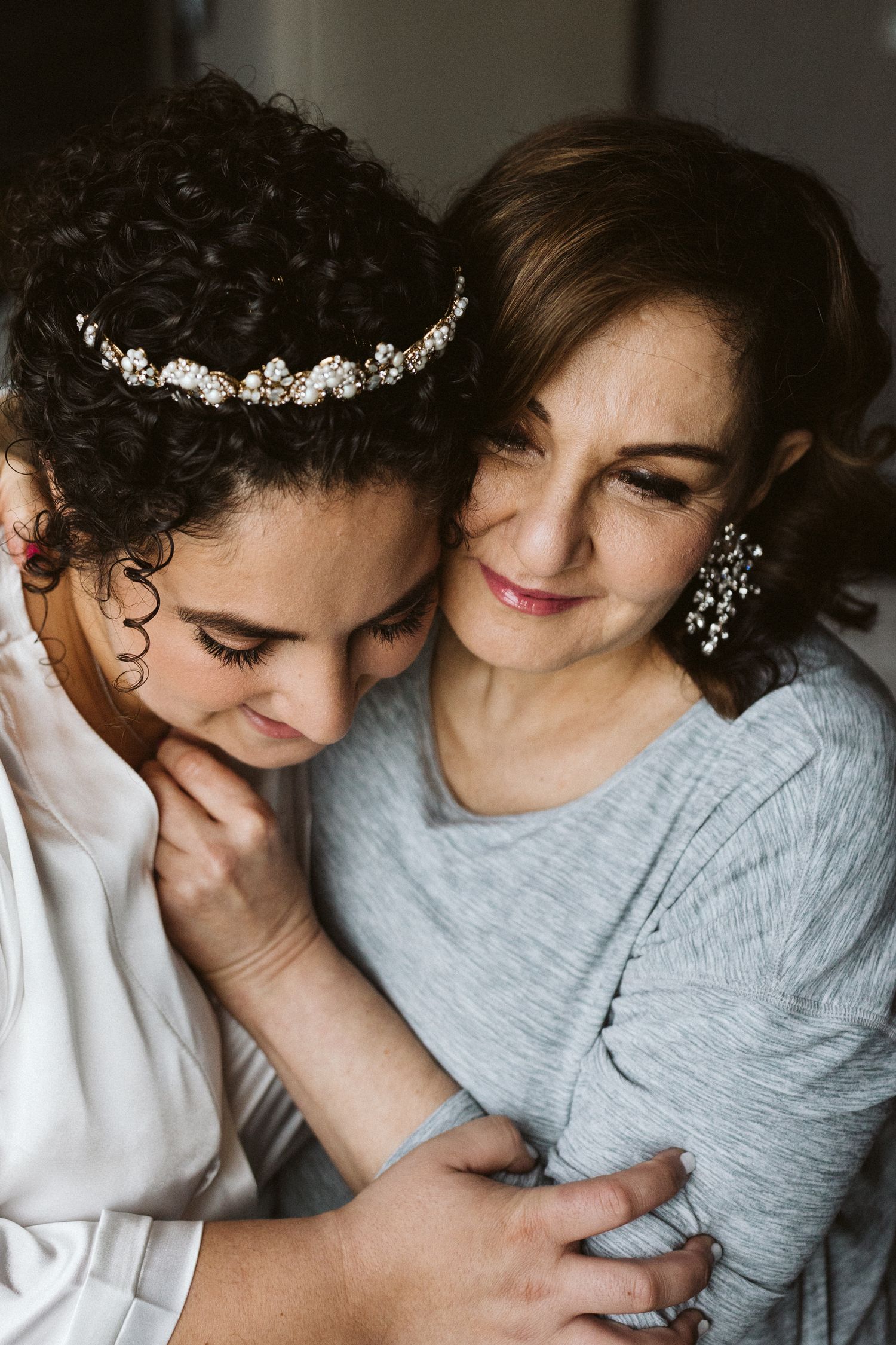 Two people share an intimate moment while wearing white and grey clothing.