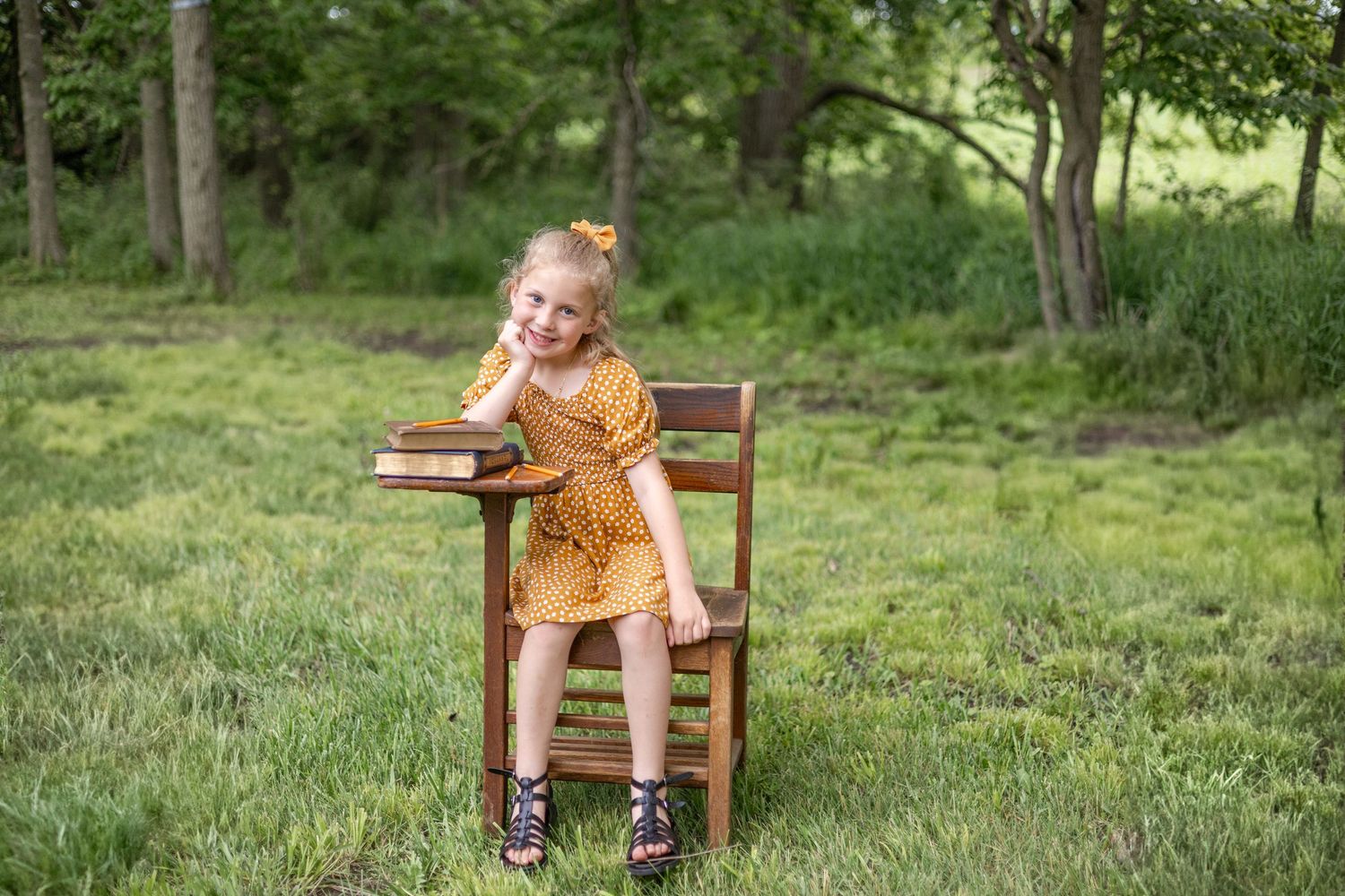 Springfield, IL Photographer captures a girl sitting at an antique wooden desk with a book during a mini session in Central, IL