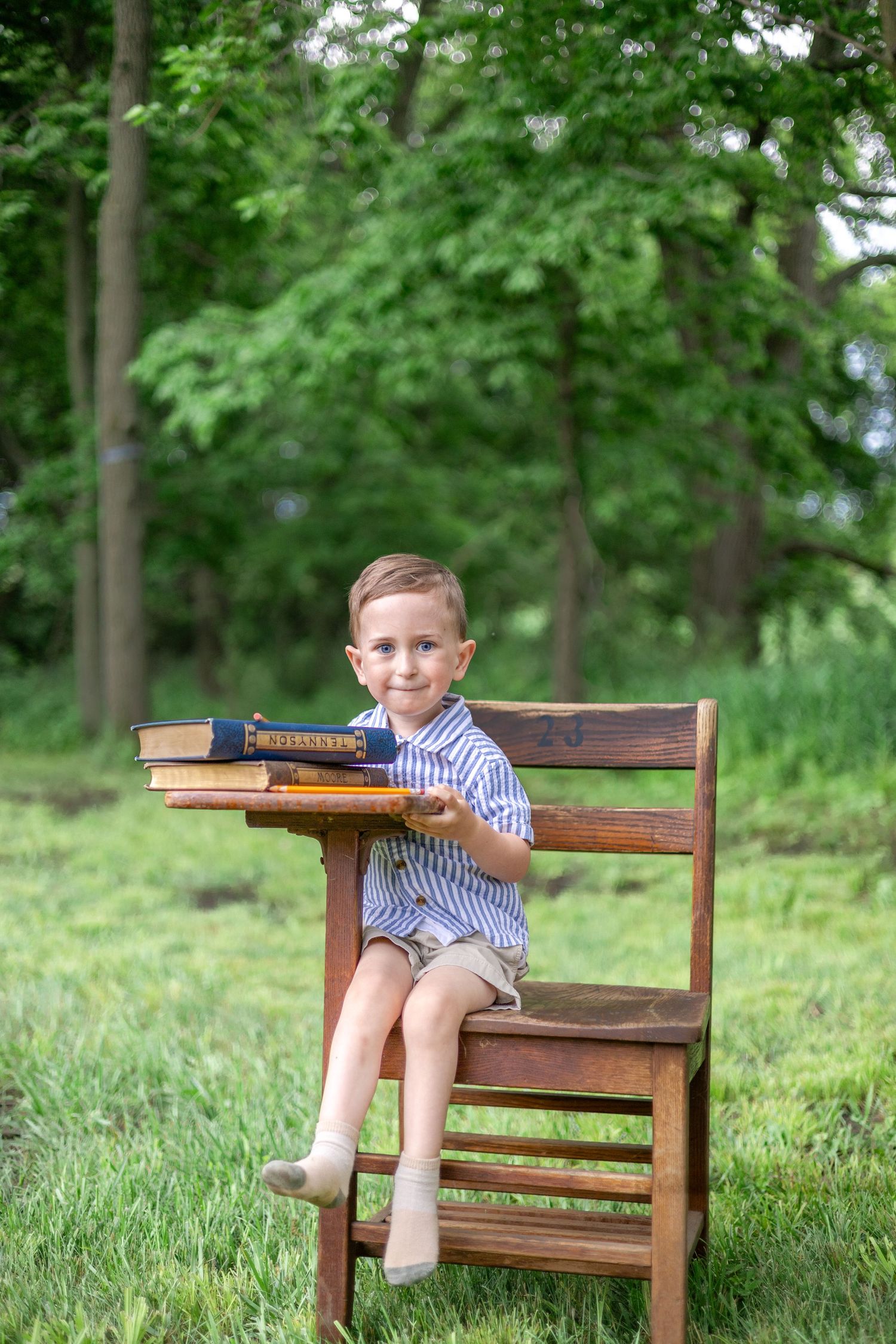 Springfield, IL Photographer captures a boy sitting at an antique wooden desk with a book during a mini session in Central, IL