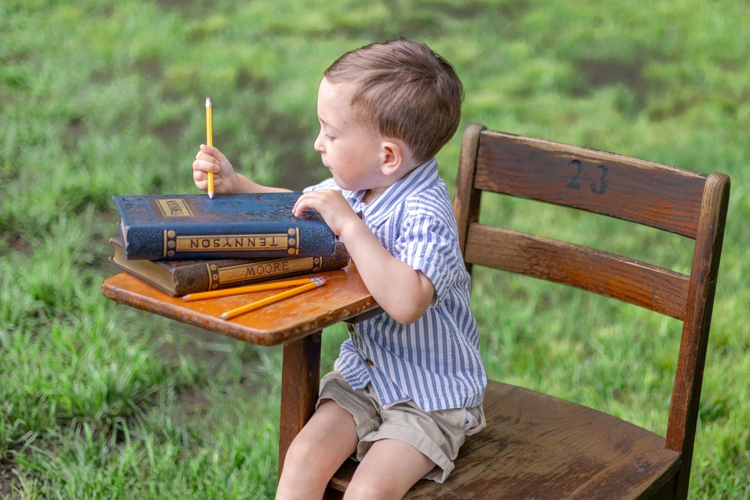 Springfield, IL Photographer captures a boy sitting at an antique wooden desk with a book during a mini session in Central, IL