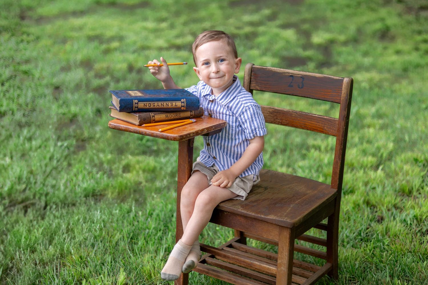 Springfield, IL Photographer captures a boy sitting at an antique wooden desk with a book during a mini session in Central, IL
