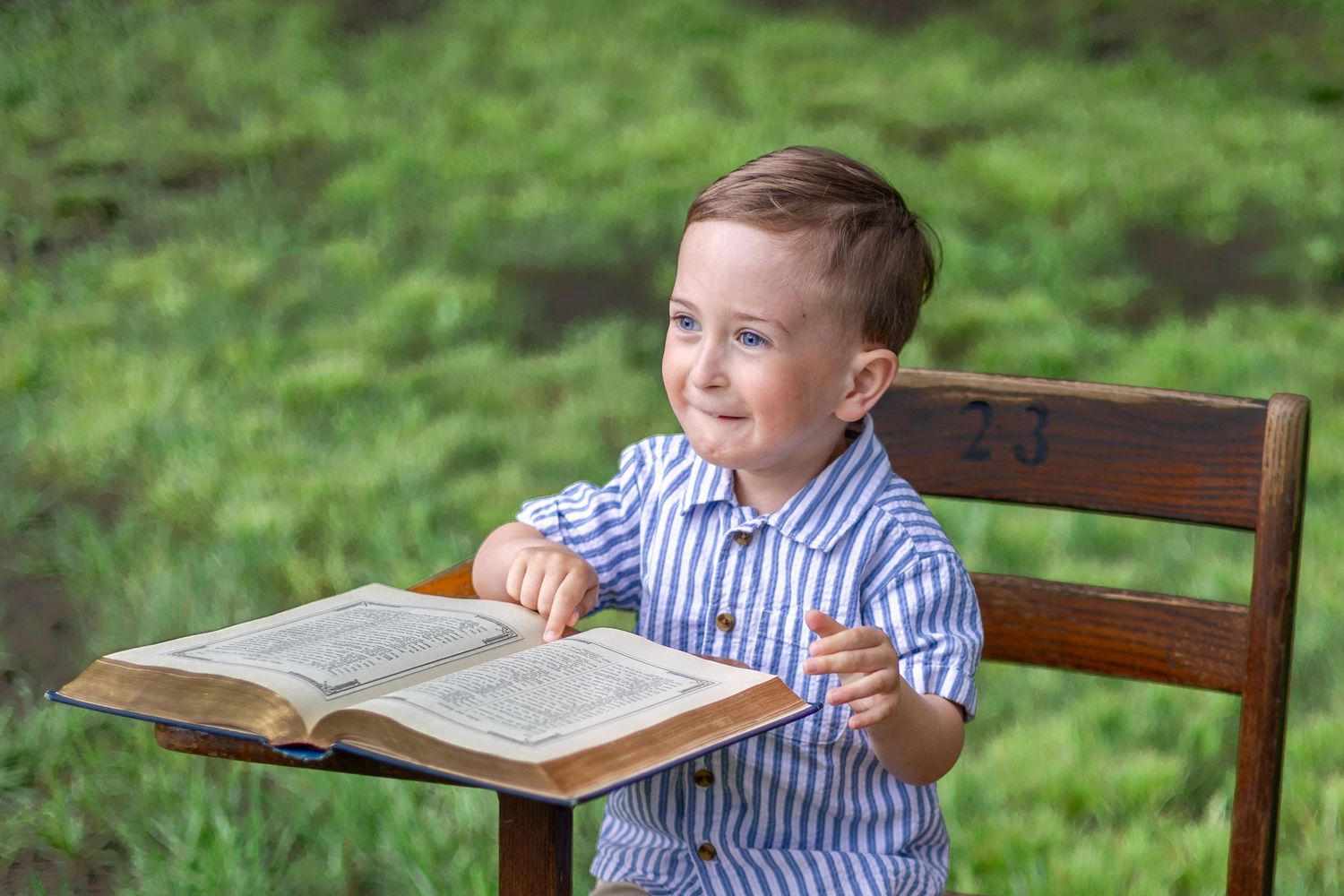 Springfield, IL Photographer captures a boy sitting at an antique wooden desk with a book during a mini session in Central, IL