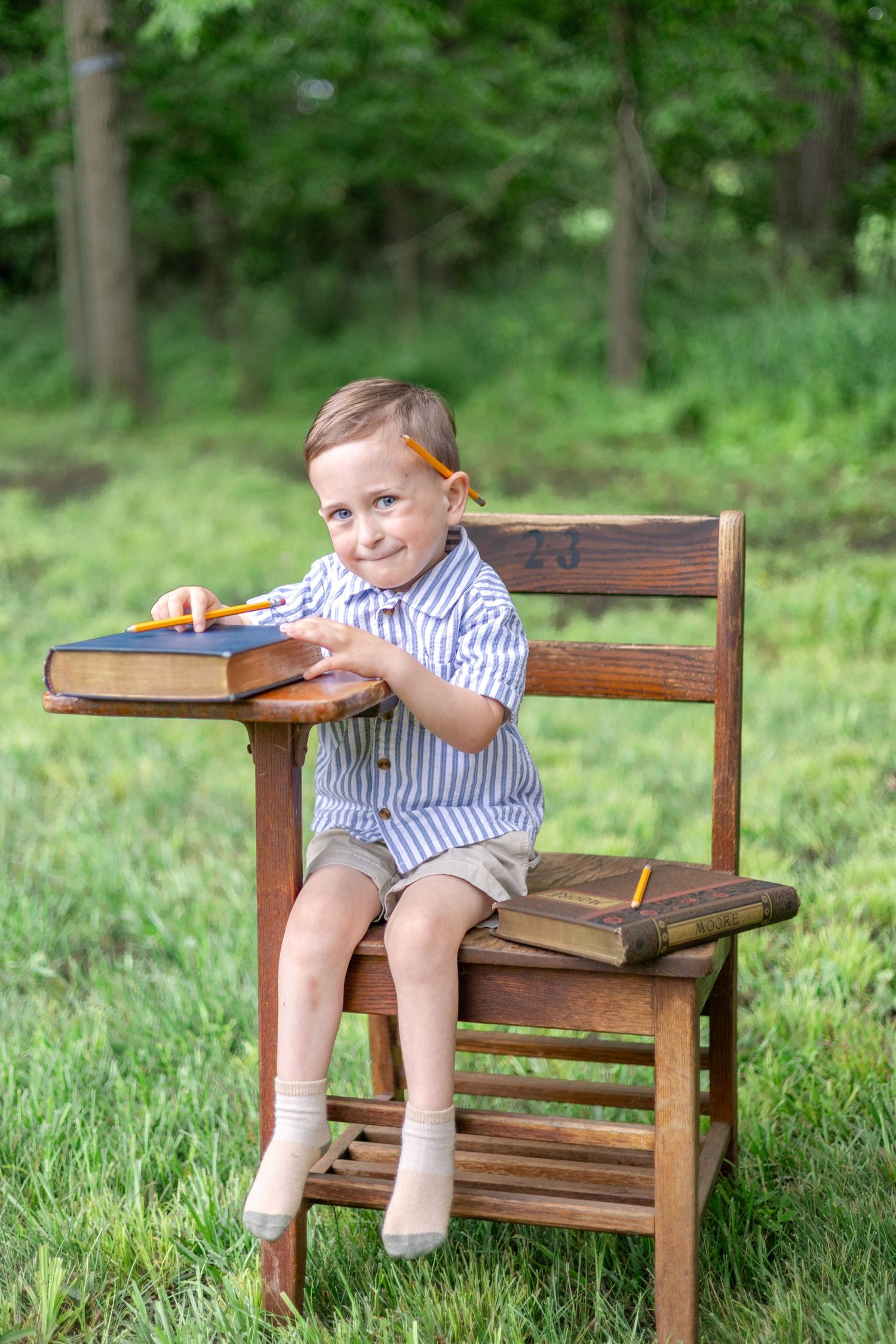 Springfield, IL Photographer captures a boy sitting at an antique wooden desk with a book during a mini session in Central, IL