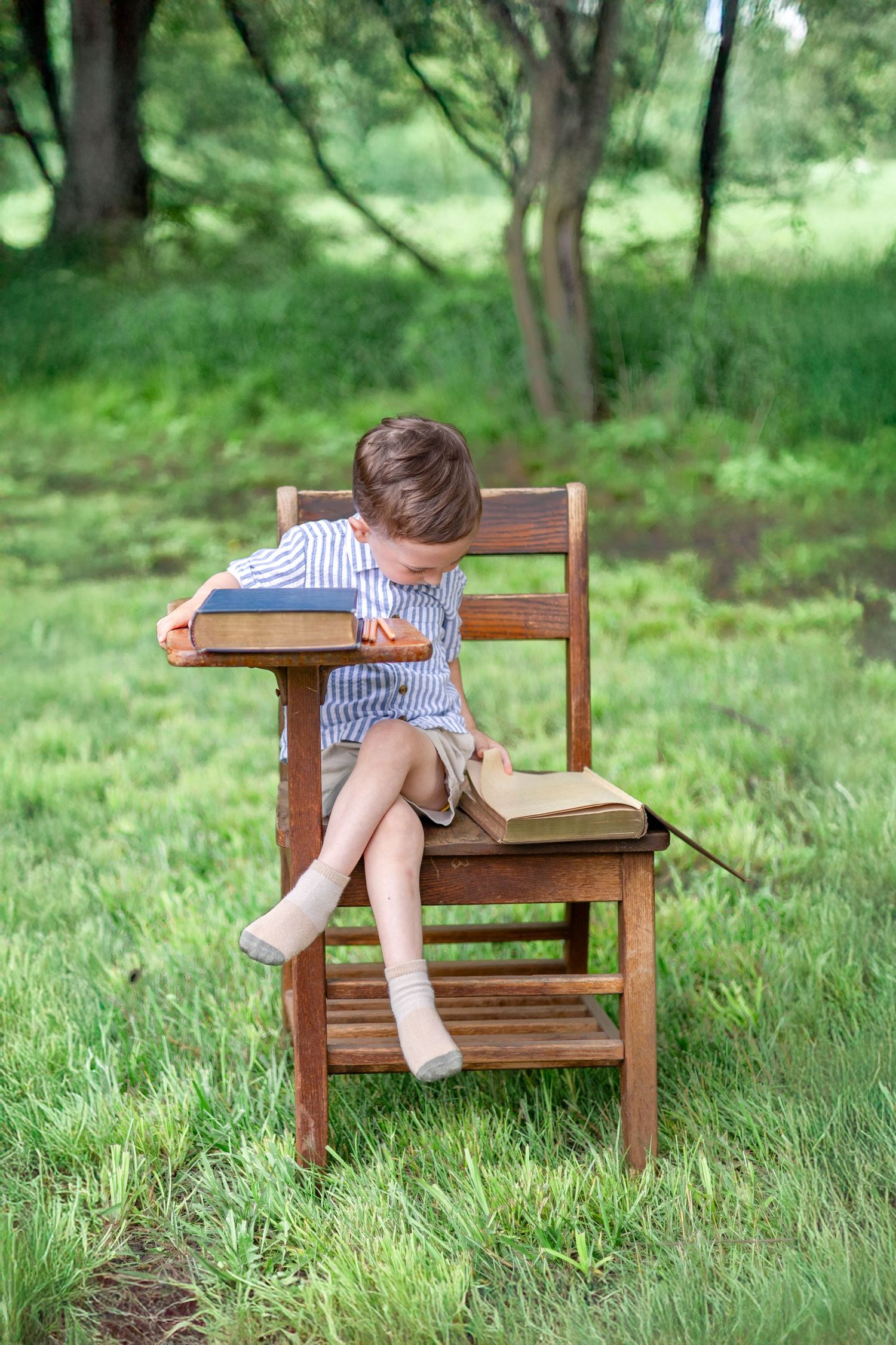 Springfield, IL Photographer captures a boy sitting at an antique wooden desk with a book during a mini session in Central, IL