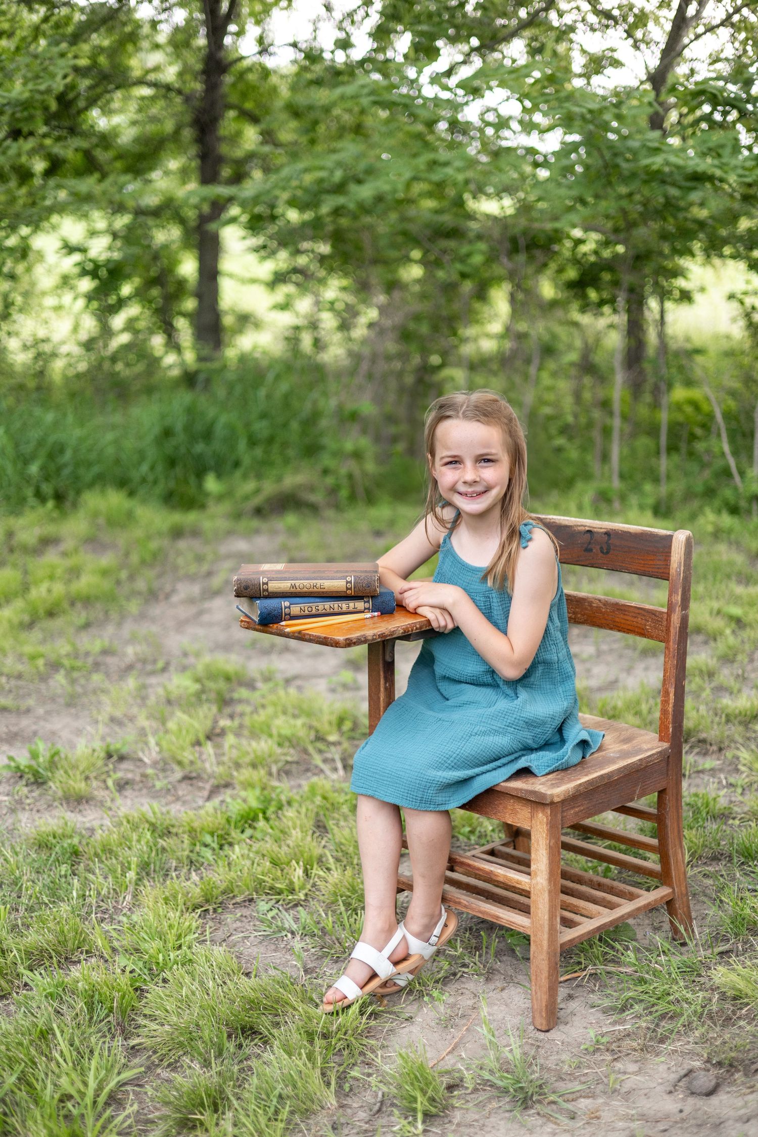 Springfield, IL Photographer captures a girl sitting at an antique wooden desk with a book opened up during a mini session in Central, IL