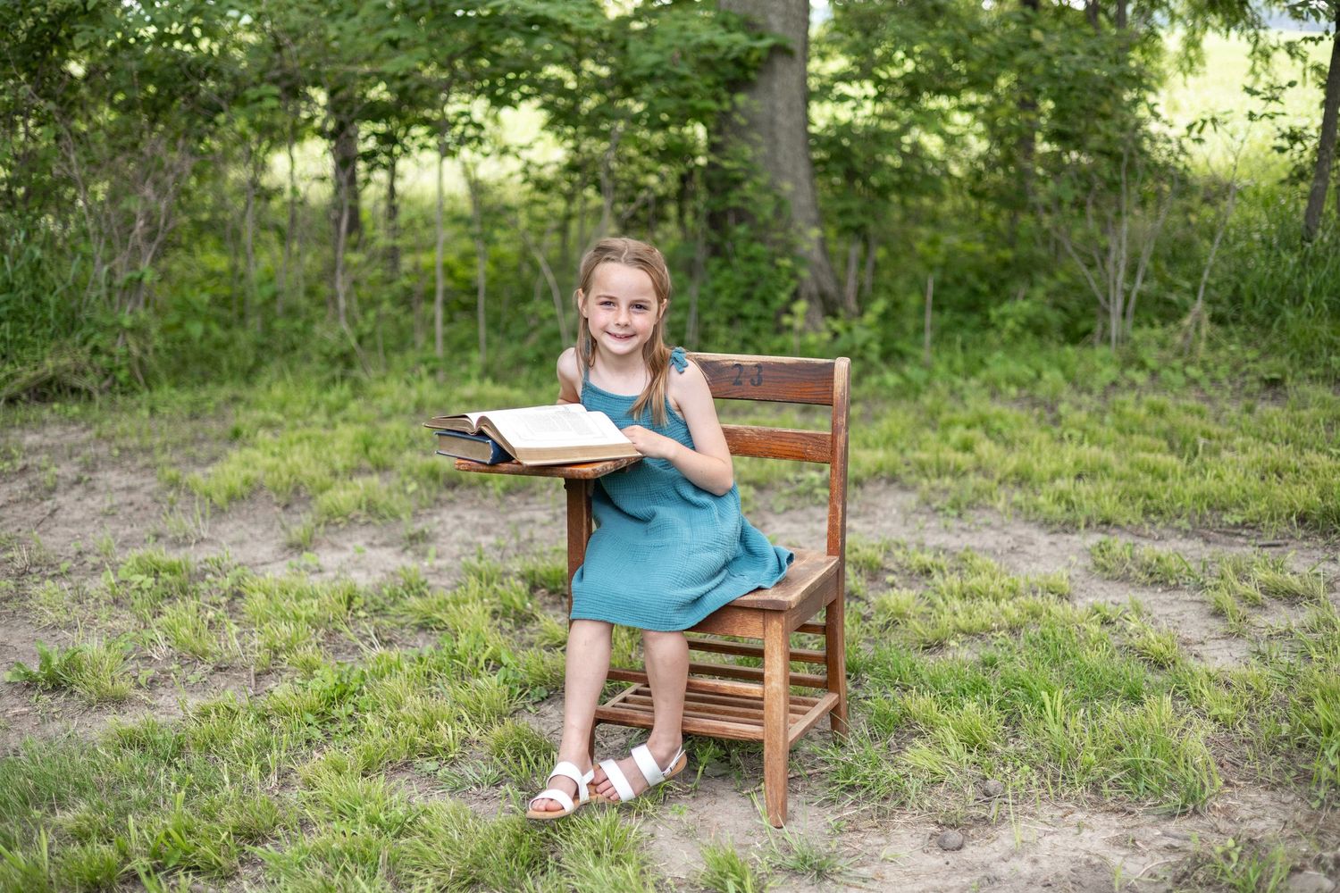 Springfield, IL Photographer captures a girl sitting at an antique wooden desk with a book opened up during a mini session in Central, IL