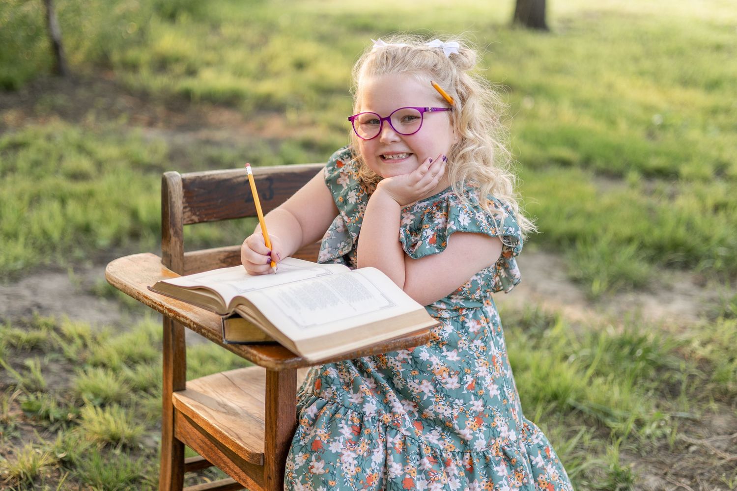 Springfield, IL Photographer captures a girl sitting at an antique wooden desk with a book opened up during a mini session in Central, IL
