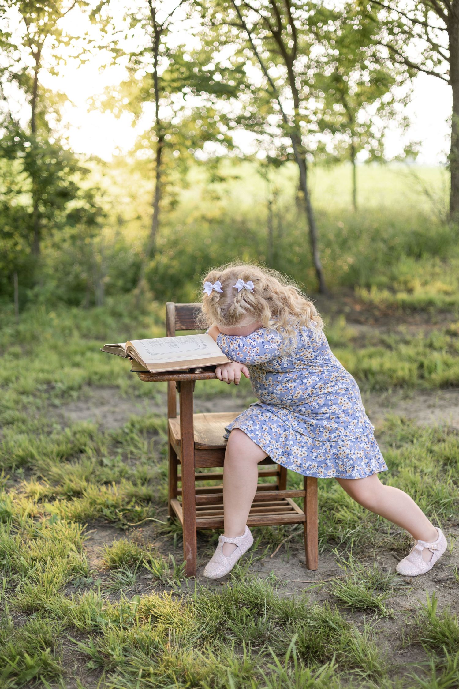 Springfield, IL Photographer captures a girl sitting at an antique wooden desk with her head down during a mini session in Central, IL