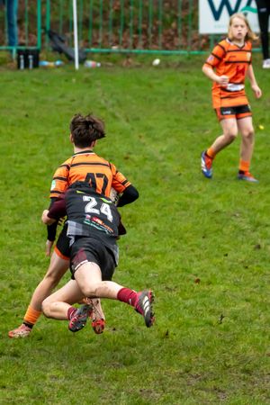Rugby Player lunges into a tackle, winning their team some time.