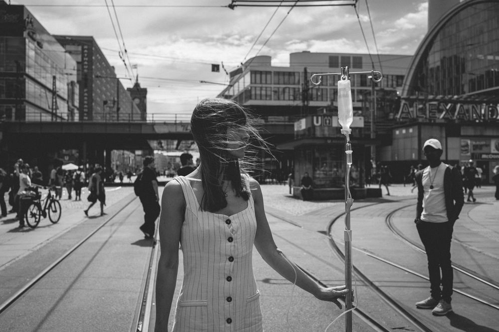 A vintage black and white streetscape shows trams and pedestrians on a city street with buildings in the background.