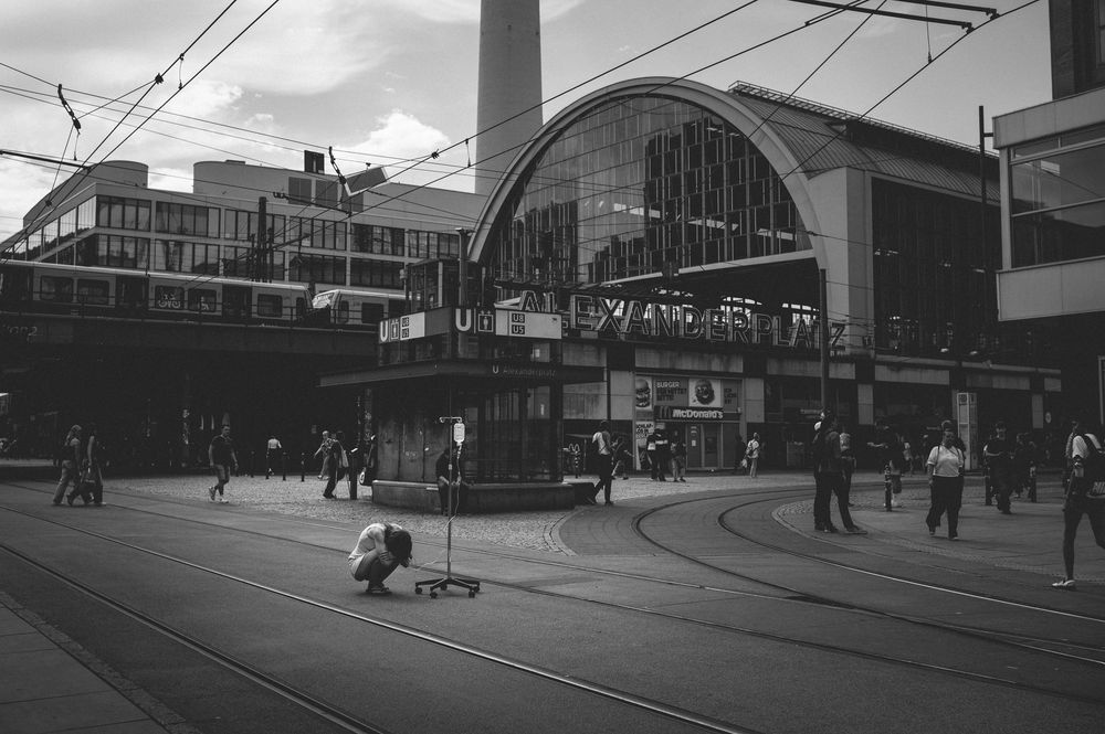 Urban transit streetcar line with array of power lines and buildings along a curved city street.