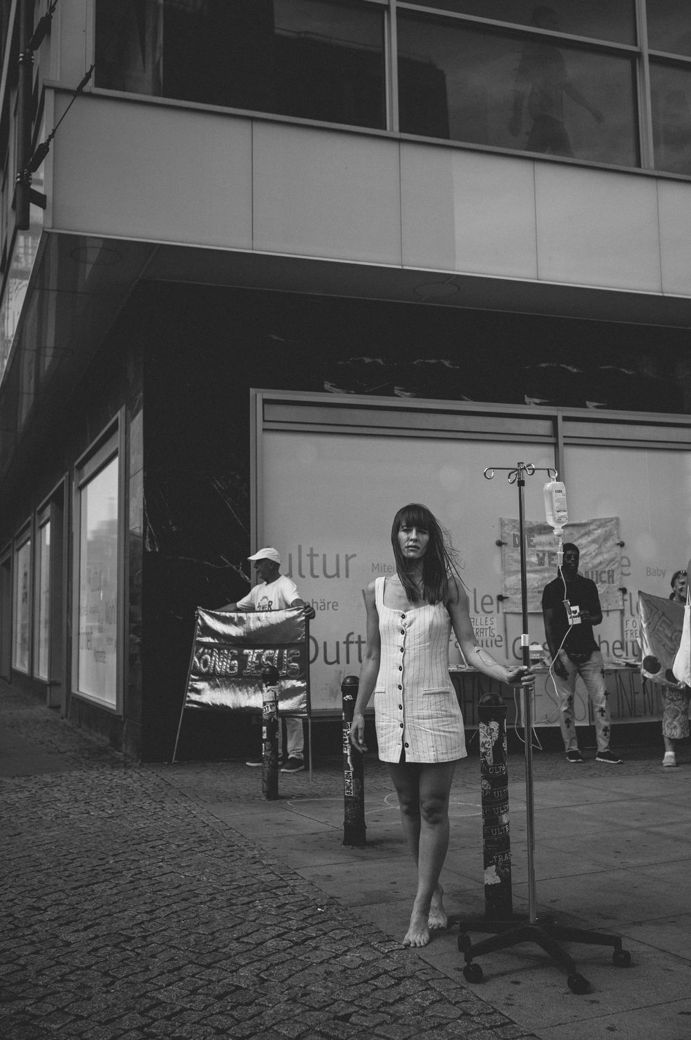 A black and white vintage street scene with a storefront and cobblestone street in an urban setting.