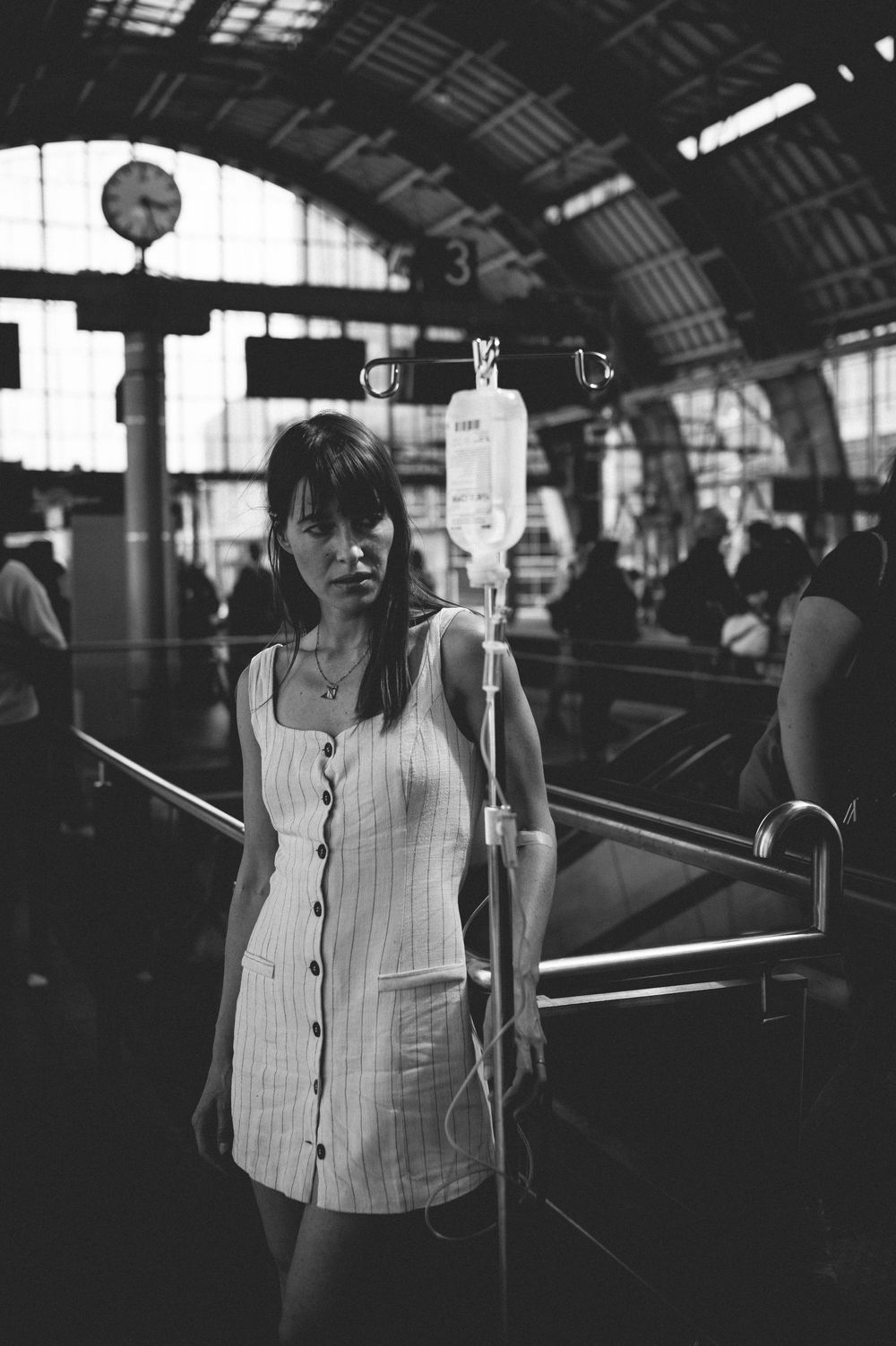 A monochromatic portrait series of a person wearing a white button-up shirt in a train station setting.