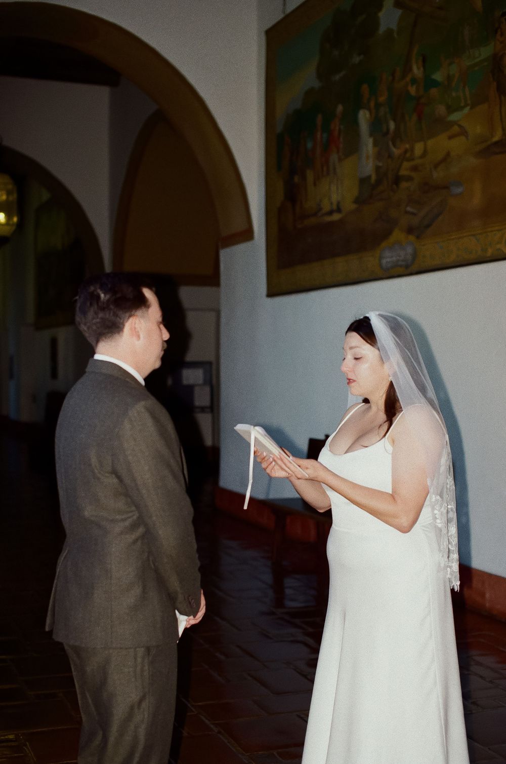 Timeless portrait of newlyweds walking through Santa Barbara Courthouse reading vows