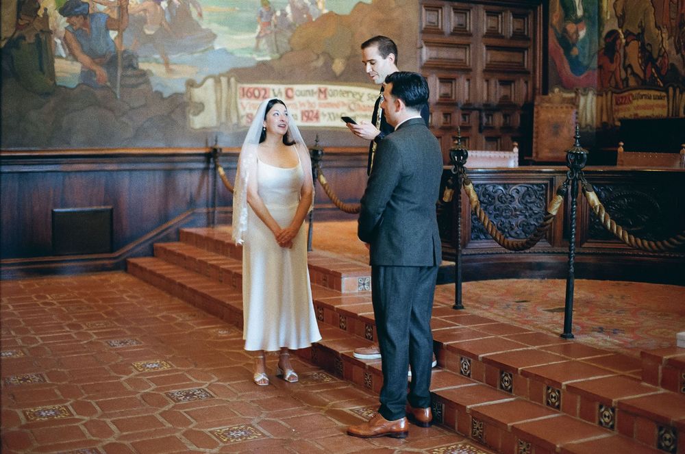 Timeless film photo of couple surrounded by Spanish Revival architecture.